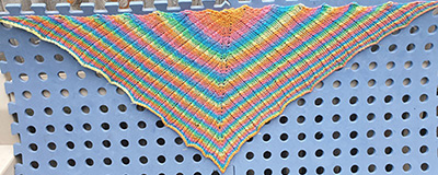 A Cabley shawl being blocked on some blocking mats.